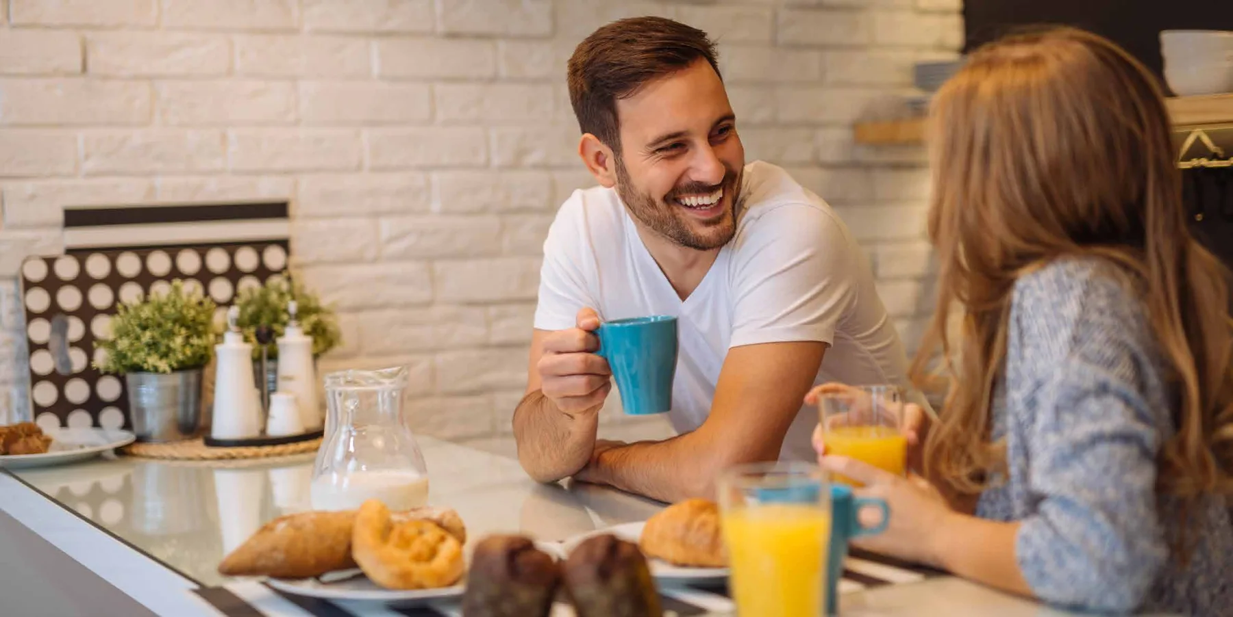 Casal conversando durante o café da manhã em casa